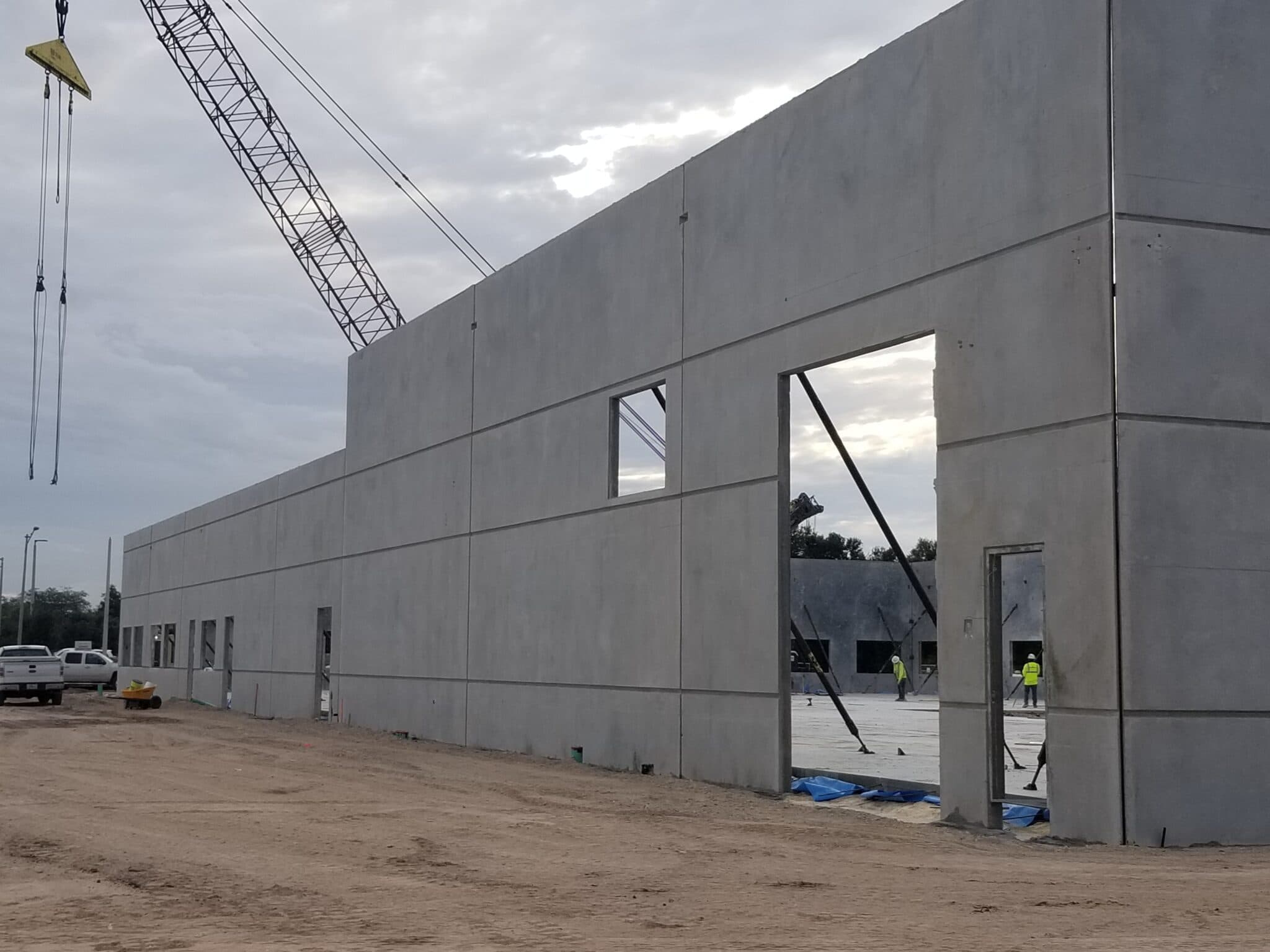 Tilt-wall concrete panels being lifted into place at a commercial construction site